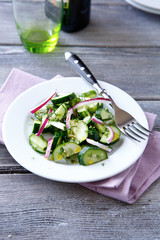 Fresh salad with cucumber on a white plate