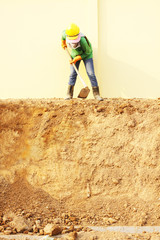 Laborer digging with hoe on construction site