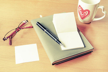 Cup of coffee with notebook and blank memo