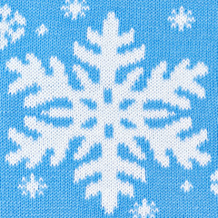 Knitted blue background with snowflakes