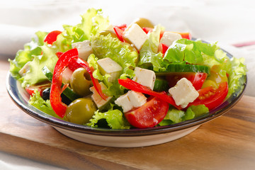 Greek  salad with feta, olives and vegetables .