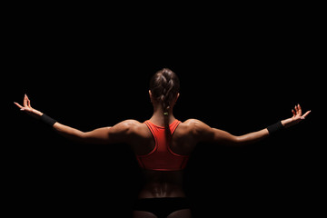 Athletic young woman showing muscles of the back