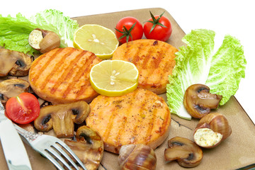 roasted salmon medallions with mushrooms and vegetables closeup