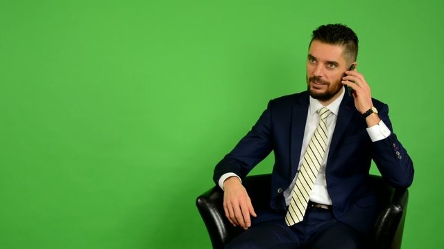 business man sits and phone - green screen - studio
