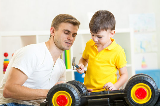 kid boy and his dad repair toy car