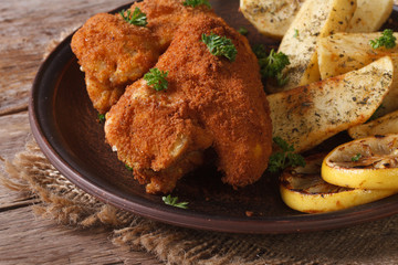 chicken wings dipped in batter with potatoes and lemon