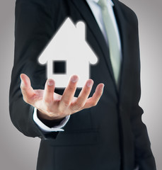 Businessman standing posture hand holding house icon isolated