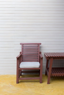 wooden chair on yellow cement floor with mortar wall background