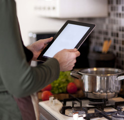 cooking, technology and home concept -a woman, a housewife in th