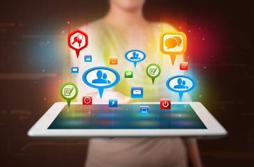 Girl presenting a tablet with colorful social icons and signs