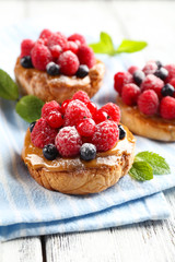 Sweet cakes with berries on table close-up