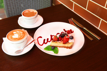 Cup of coffee and tasty cupcake on table in cafe