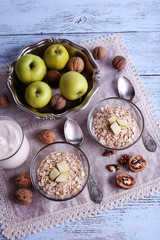 Oatmeal in bowls, walnuts, apples and yogurt