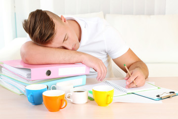 Naklejka premium Tired man with many folders sleeps on table