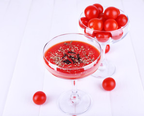 Tomato juice in glass goblet and fresh tomatoes
