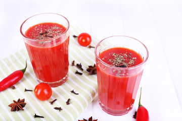 Tomato juice in glasses and fresh vegetables
