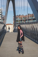Beautiful young brunette posing on a bridge