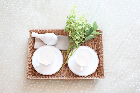 Decorative tray with tea set and flower on the bed