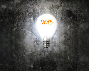 bright 2015 light bulb illuminated dark old mottled concrete wal