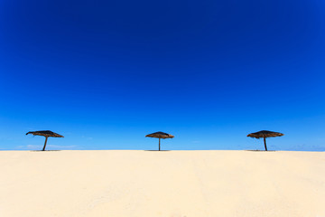 Wooden sun umbrella on the beach in Thailand