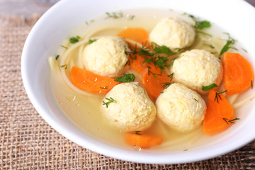 Soup with meatballs and noodles in bowl