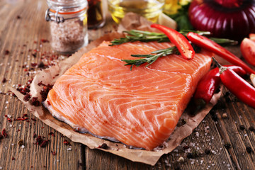 Fresh salmon with spices on wooden table