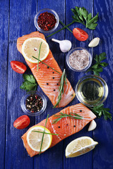 Fresh salmon with spices and lemon on wooden table