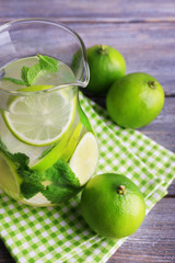 Lemonade in pitcher on wooden background