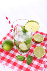 Lemonade in glass on napkin on bright background
