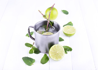 Lemonade in metal cup on wooden background