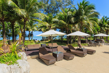 sun loungers and umbrella stand at the pool