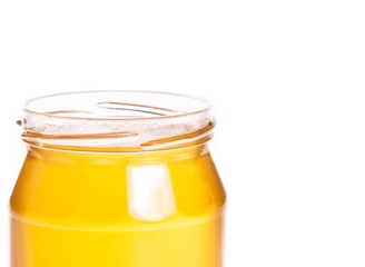 closeup of opened honey jar on white background