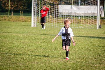 Young child boy playing soccer
