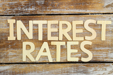 Interest rates written with wooden letters on rustic wood