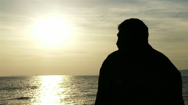 Mature Man in the Sunset Silhouette at Lake