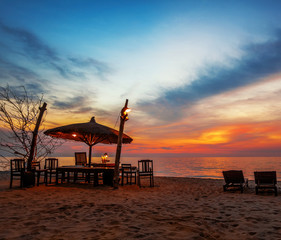 Wooden chairs and umbrellas on sand beach
