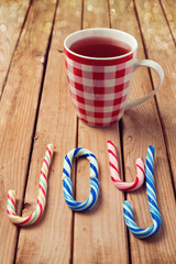 Candy cane and mulled wine over wooden background