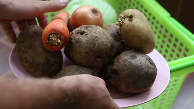 man puts on a tray for borsch vegetables - beets, potatoes, onio