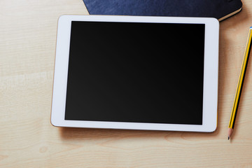 Blank screen on a white tablet pc with an organiser and a pencil