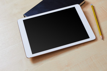 Blank screen on a white tablet pc with an organiser and a pencil