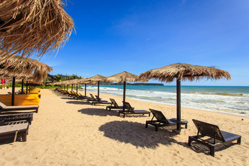 Sun umbrella and sun loungers stand at the beach in Phuket, Thai