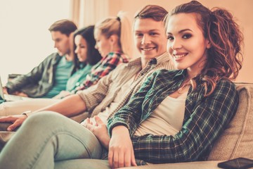 Students preparing for exams in apartment interior behind table
