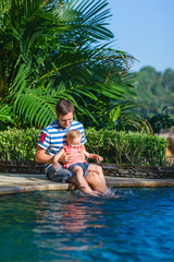 Father and daughter near swimming pool