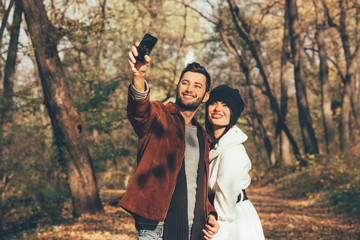 Young couple taking selfie in the park