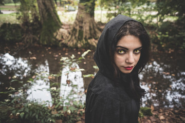 beautiful dark vampire woman with black mantle and hood
