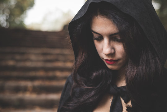 beautiful dark vampire woman with black mantle and hood