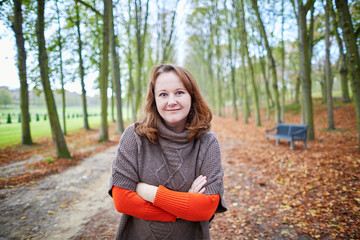 Cheerful girl in forest or park on a fall day