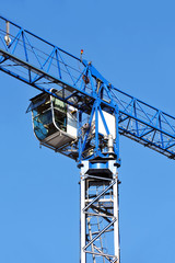 Blue construction tower crane against blue sky