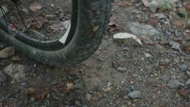 Stones flying away from mountain bicycle in slow motion