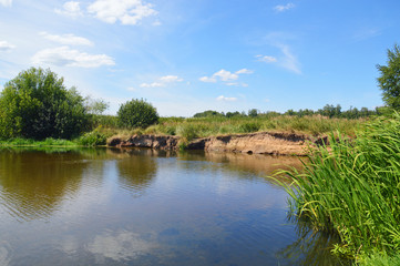 Fototapeta na wymiar Летний пейзаж с рекой и обрывистым берегом
